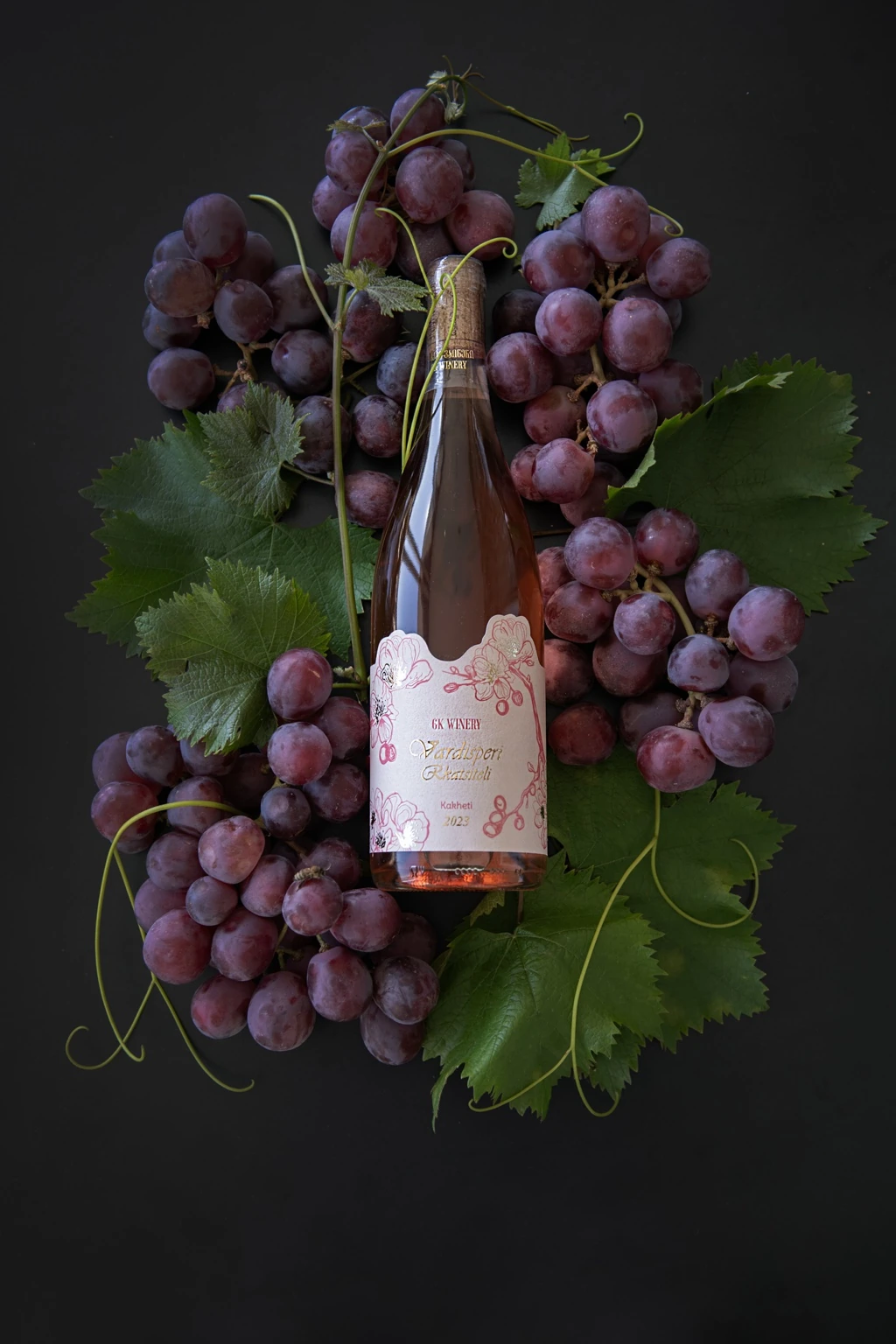 GK Winery bottle arranged among grapes
