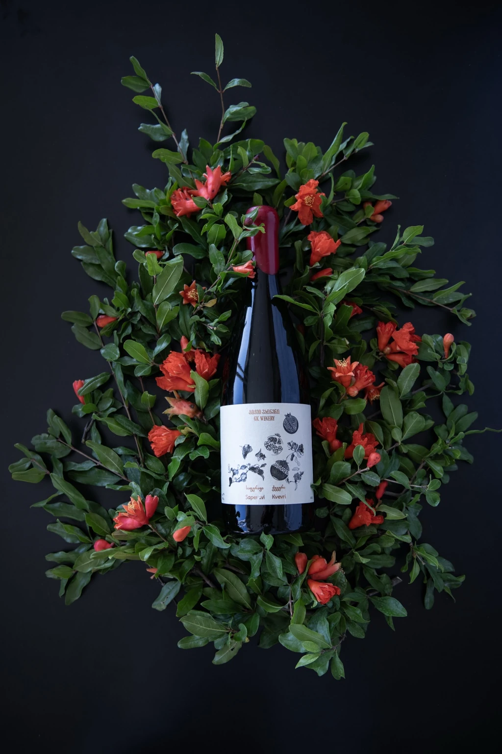 GK Winery bottle arranged with pomegranates and flowers