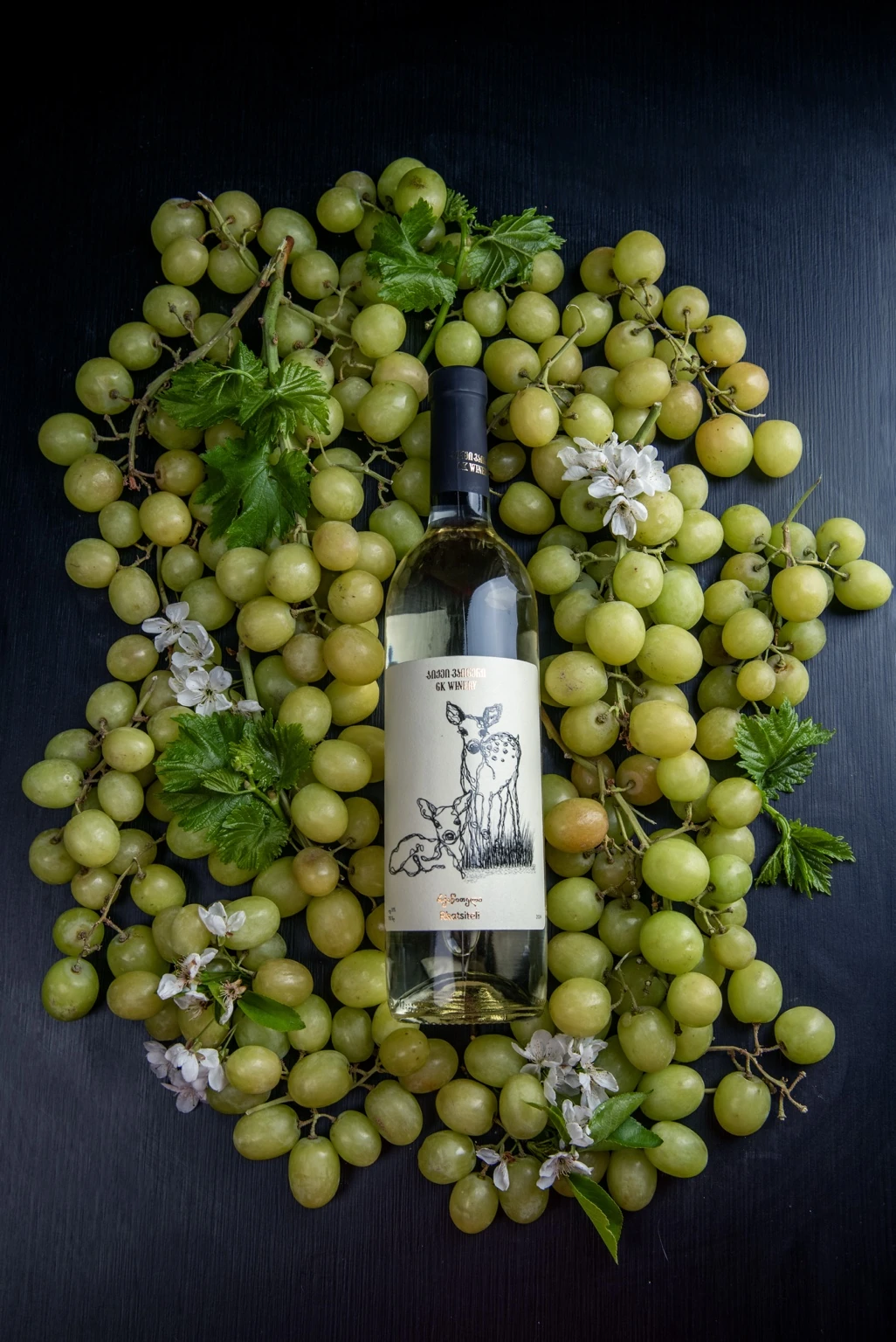 GK Winery bottle arranged among green grapes